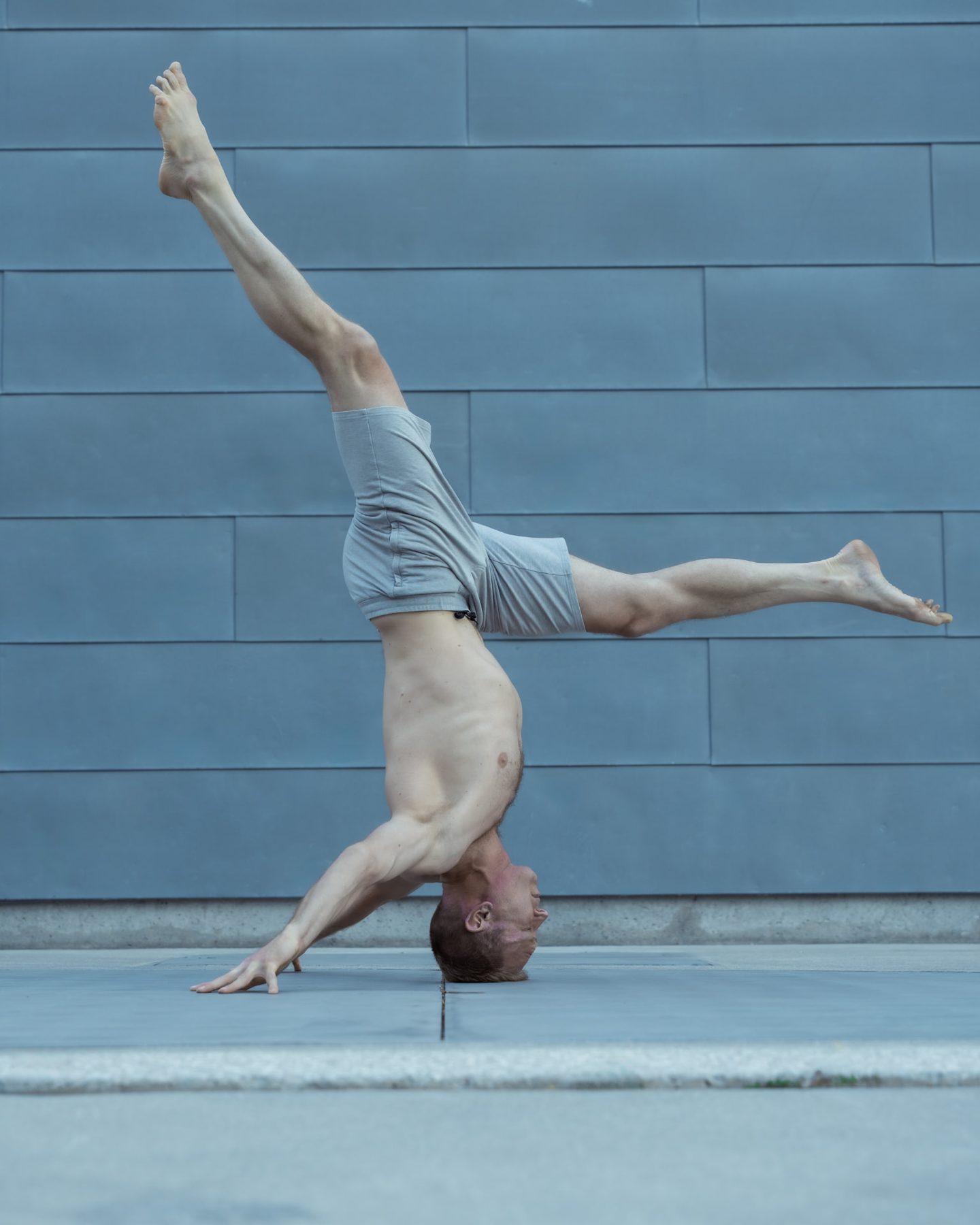 Christopher Gillett in a headstand with legs split